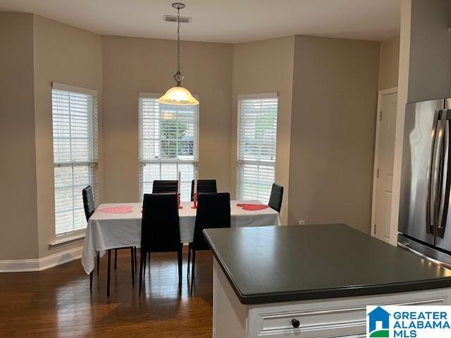 dining area featuring visible vents, dark wood finished floors, and baseboards