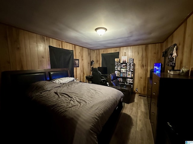 bedroom featuring wood walls and light wood-type flooring