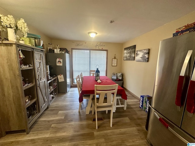 dining area with baseboards and wood finished floors