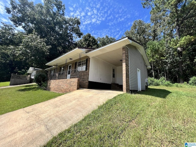 view of front of home with brick siding, a porch, a carport, driveway, and a front lawn