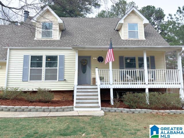 new england style home with covered porch and a shingled roof