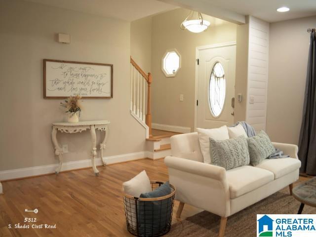 entrance foyer with recessed lighting, wood finished floors, baseboards, and stairs