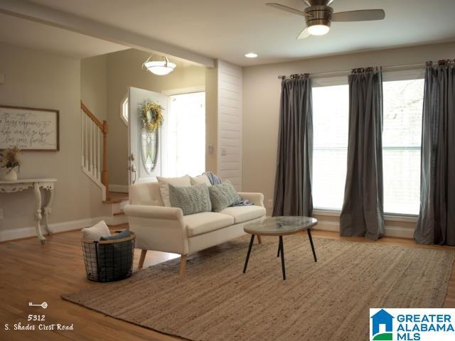 living room with recessed lighting, stairway, ceiling fan, wood finished floors, and baseboards