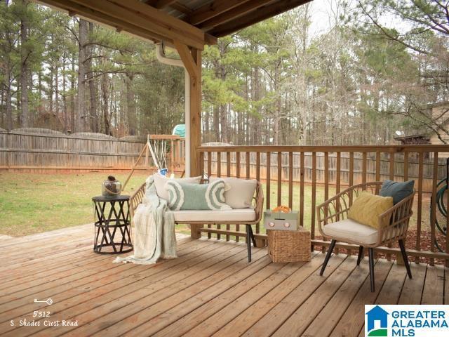 wooden terrace featuring a yard and fence