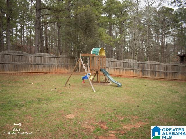 view of jungle gym featuring a fenced backyard and a lawn