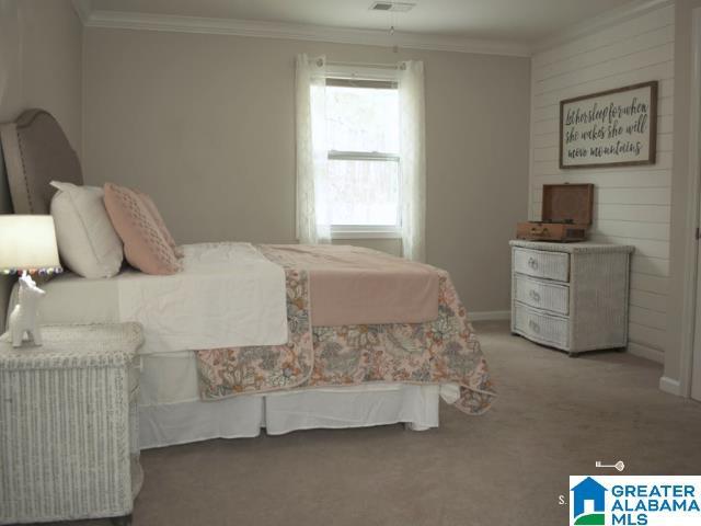 carpeted bedroom featuring baseboards and crown molding