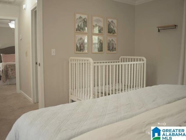 carpeted bedroom with crown molding and baseboards