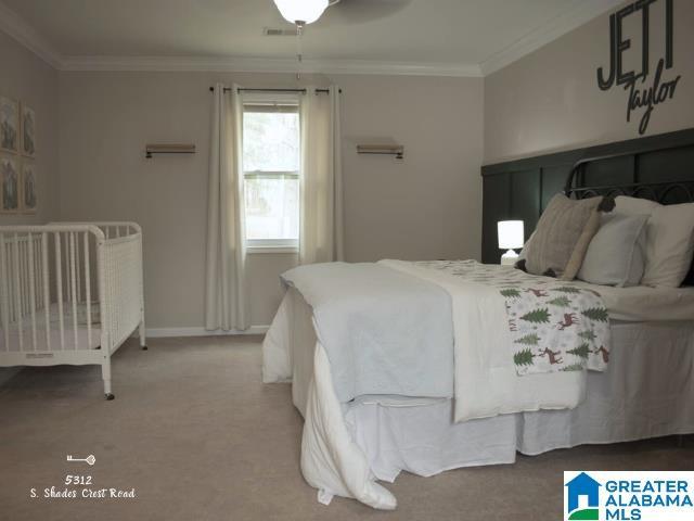 bedroom featuring light carpet, baseboards, visible vents, and crown molding