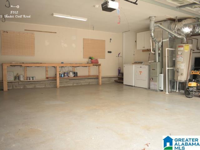 garage with a garage door opener, water heater, and washer and clothes dryer