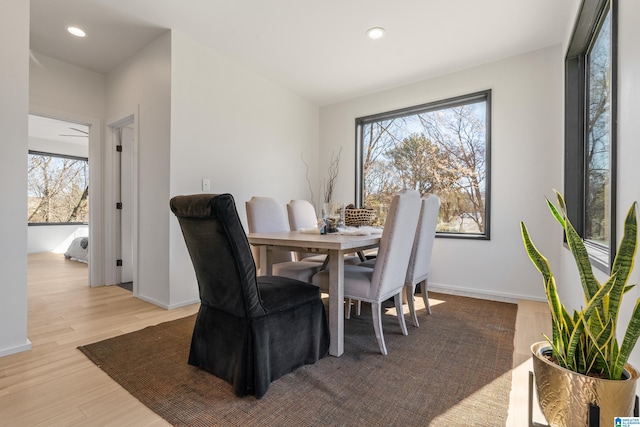 dining area with a healthy amount of sunlight, light wood finished floors, baseboards, and recessed lighting