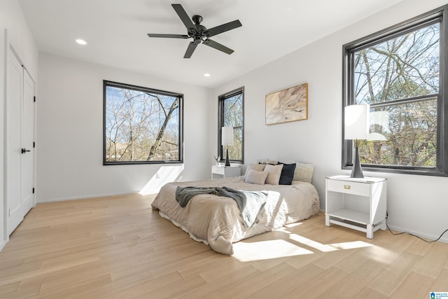 bedroom with recessed lighting, multiple windows, ceiling fan, and light wood-style flooring