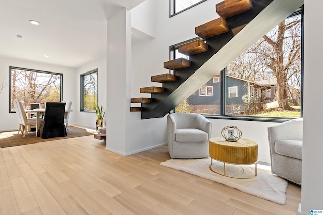 sitting room featuring light wood finished floors, stairway, recessed lighting, and baseboards