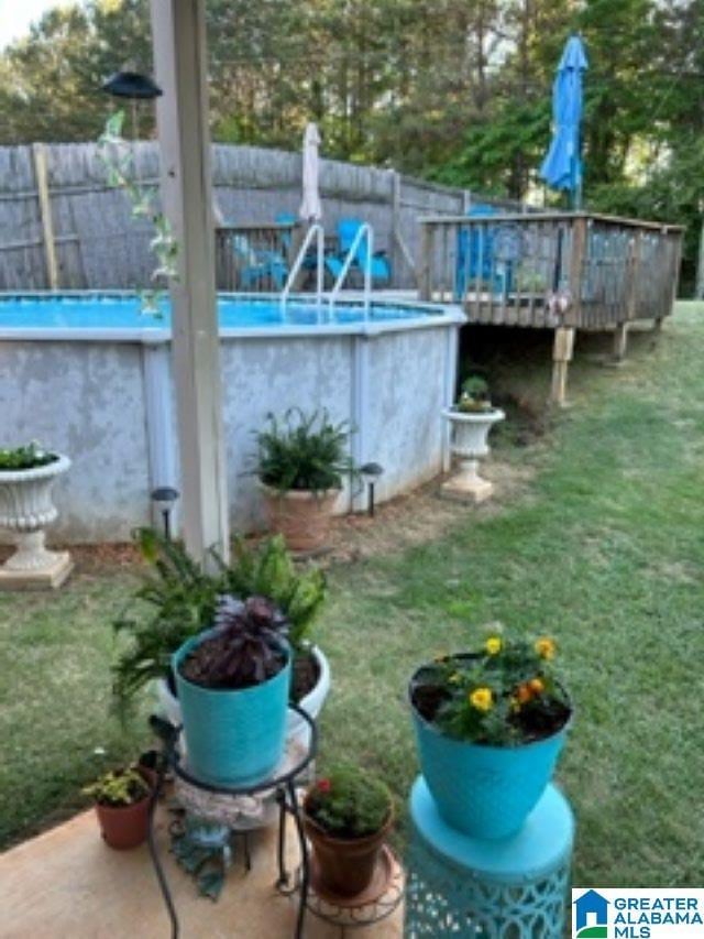 view of yard with an outdoor pool and fence