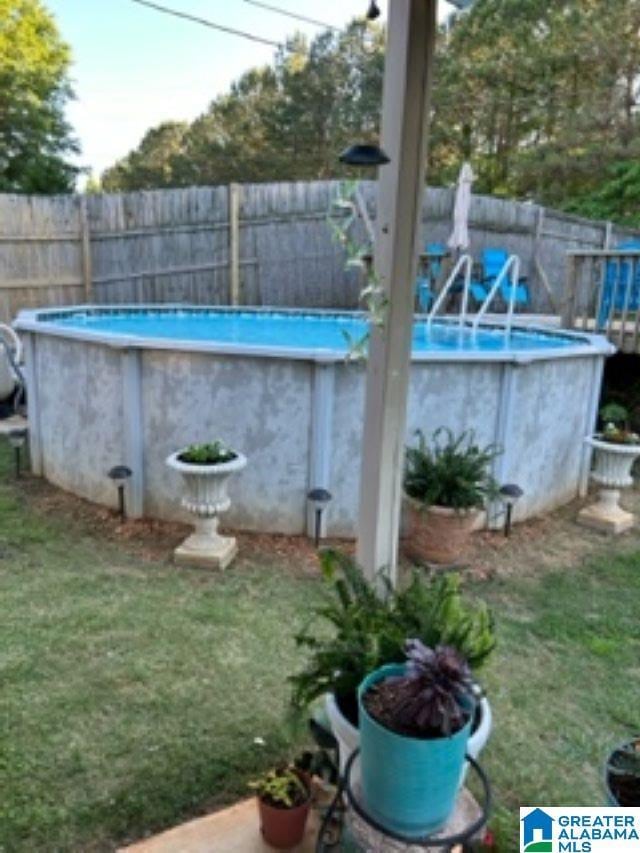 view of pool with a lawn, fence, and a fenced in pool