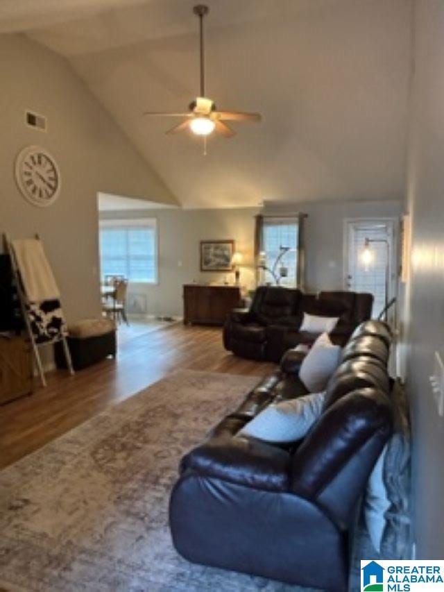 living room featuring visible vents, high vaulted ceiling, wood finished floors, and a ceiling fan