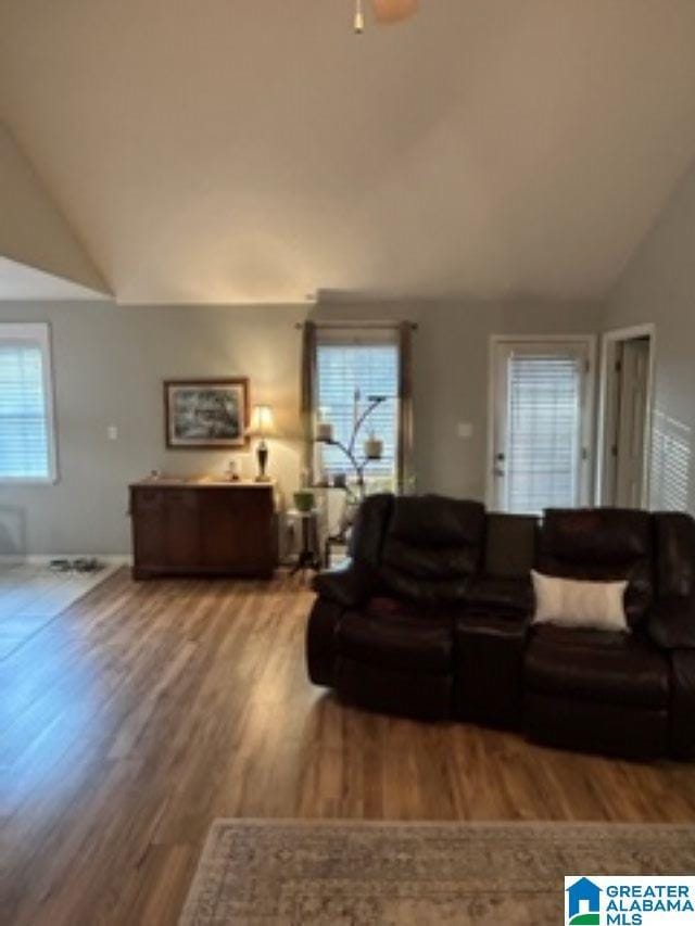 living room featuring ceiling fan, vaulted ceiling, and wood finished floors