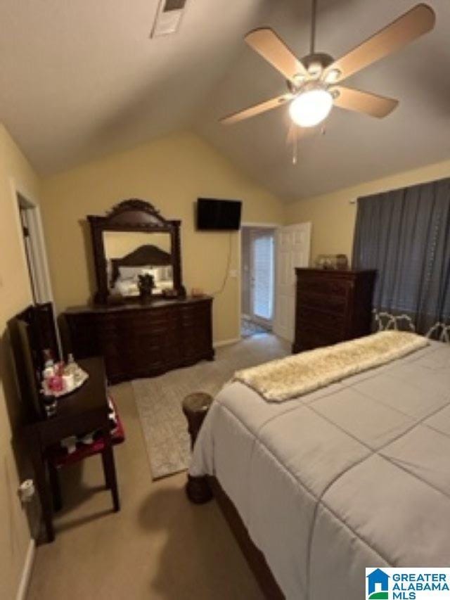 bedroom with light carpet, visible vents, vaulted ceiling, and a ceiling fan