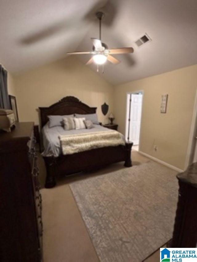 carpeted bedroom featuring lofted ceiling, baseboards, visible vents, and a ceiling fan