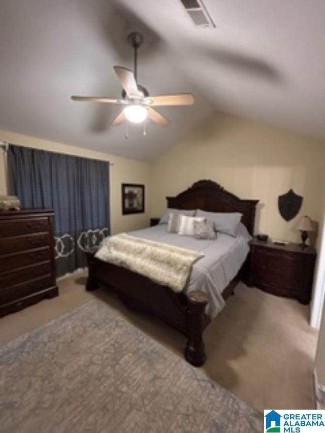 bedroom with light carpet, visible vents, vaulted ceiling, and a ceiling fan