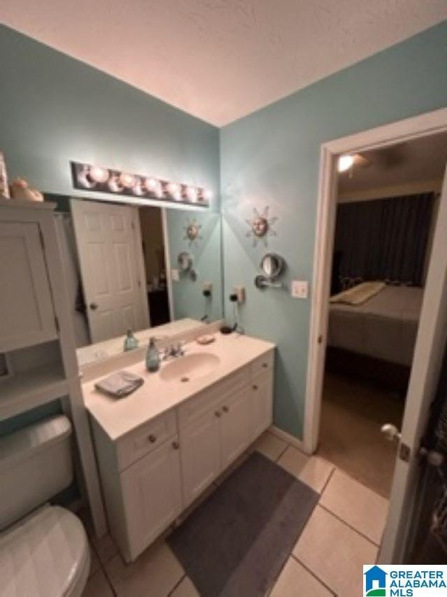 ensuite bathroom featuring toilet, vanity, connected bathroom, and tile patterned floors