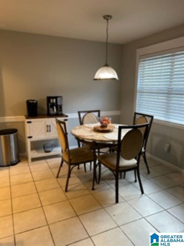 dining space featuring light tile patterned floors and baseboards