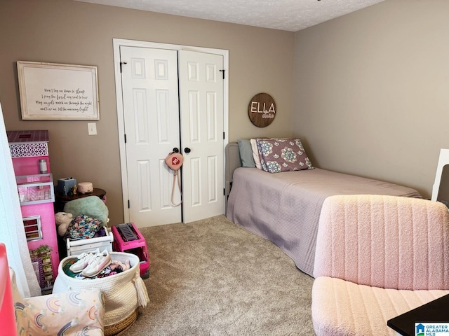 carpeted bedroom with a closet and a textured ceiling