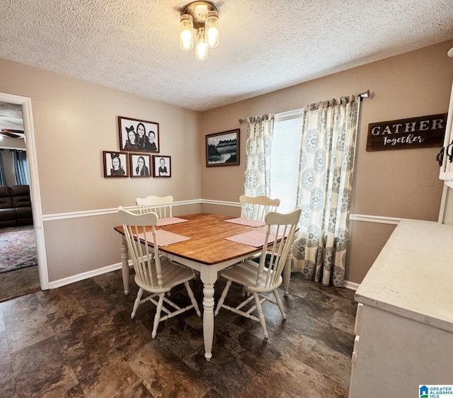 dining area featuring a textured ceiling and baseboards