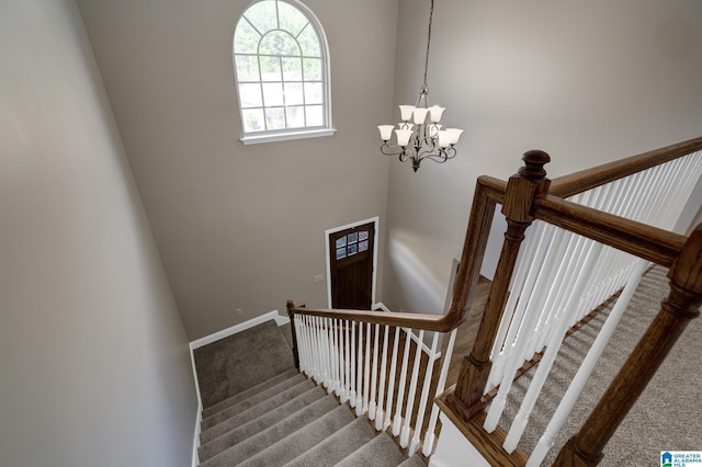 stairway with carpet floors, baseboards, and a chandelier