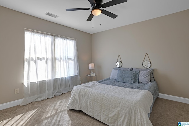 bedroom with carpet flooring, visible vents, ceiling fan, and baseboards