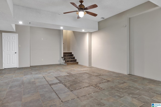 finished below grade area with recessed lighting, visible vents, ceiling fan, and stairs