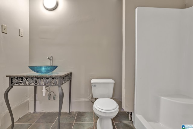 bathroom featuring a sink, toilet, and tile patterned floors