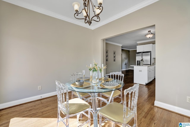 dining area featuring crown molding, a chandelier, wood finished floors, and baseboards