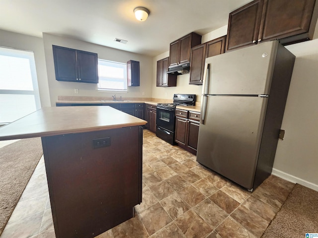 kitchen with visible vents, black electric range oven, a center island, freestanding refrigerator, and under cabinet range hood