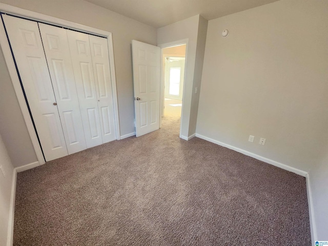 unfurnished bedroom featuring carpet floors, a closet, and baseboards