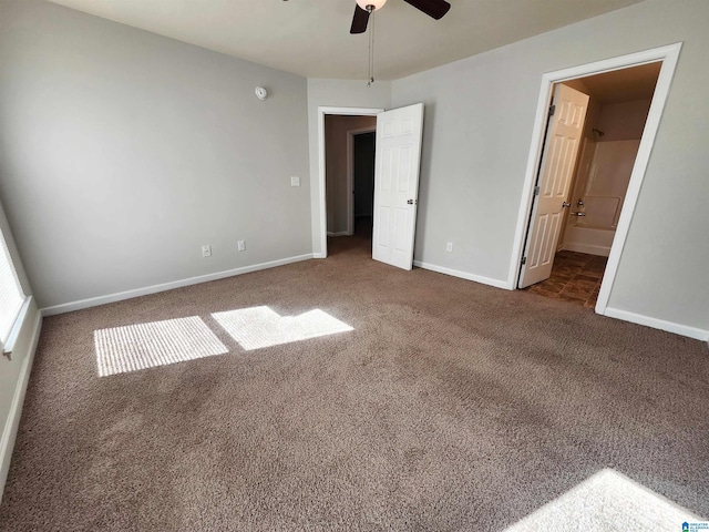 unfurnished bedroom with a ceiling fan, carpet flooring, baseboards, and ensuite bathroom