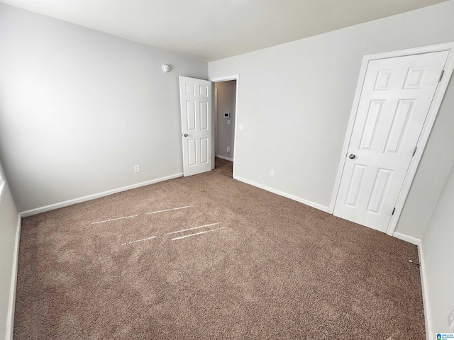 unfurnished bedroom with carpet floors and baseboards