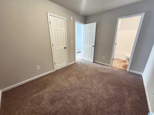 unfurnished bedroom with carpet, baseboards, and ensuite bathroom