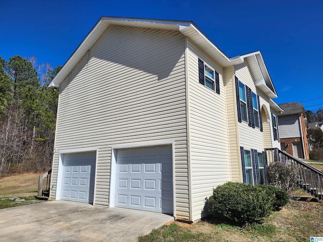 view of home's exterior with a garage and concrete driveway