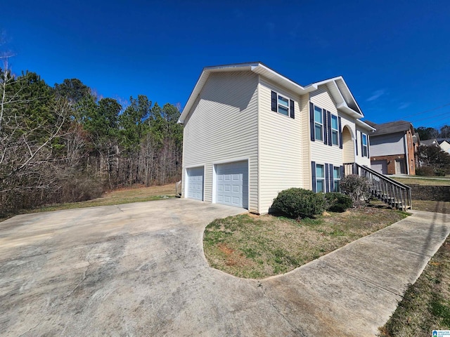 view of side of home featuring driveway and an attached garage