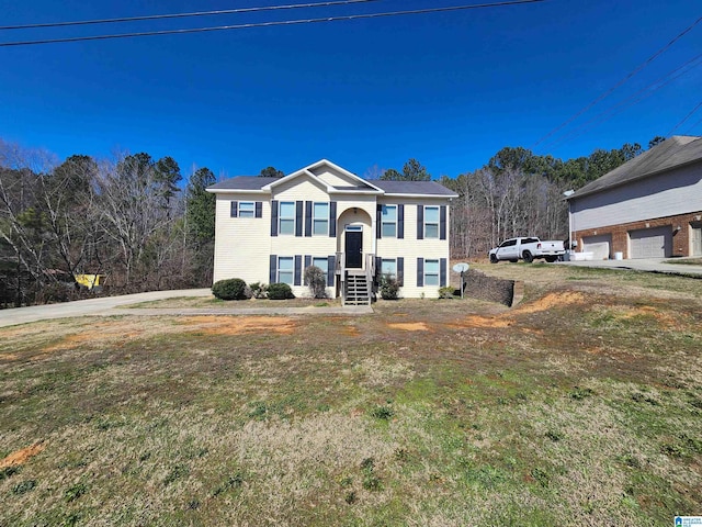 split foyer home with a garage and a front yard