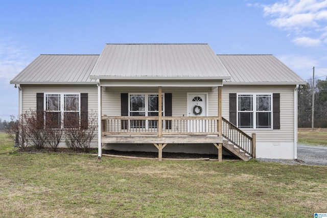 view of front of house featuring metal roof, a front lawn, and a porch