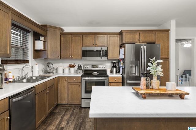 kitchen featuring dark wood-style floors, light countertops, appliances with stainless steel finishes, and a sink