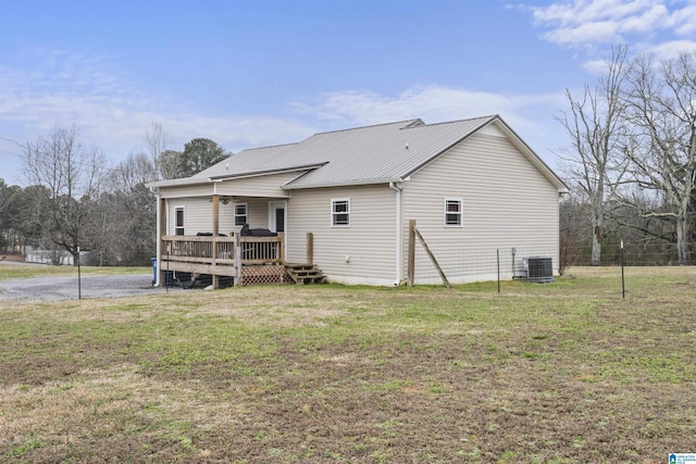 back of house with a deck, metal roof, a lawn, and central air condition unit