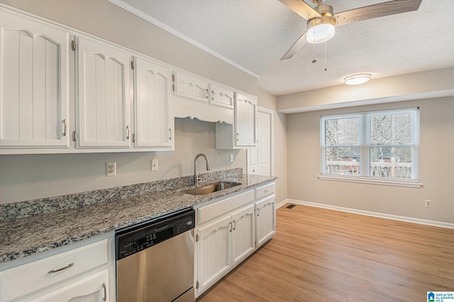 kitchen featuring dishwasher, light stone counters, a sink, and white cabinetry