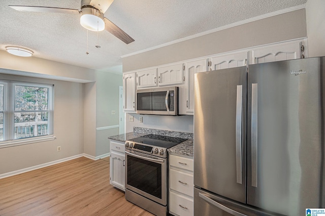 kitchen featuring white cabinets, light wood-style floors, appliances with stainless steel finishes, a textured ceiling, and stone counters