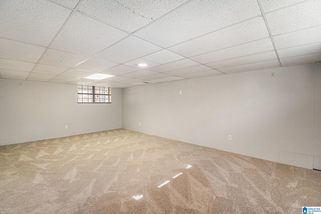 basement featuring carpet and a drop ceiling