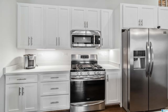 kitchen with stainless steel appliances, light countertops, and white cabinetry