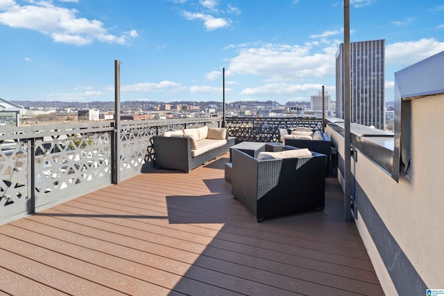 wooden terrace with a city view and an outdoor hangout area