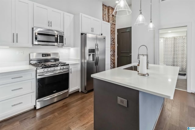 kitchen with light countertops, appliances with stainless steel finishes, a sink, and white cabinetry