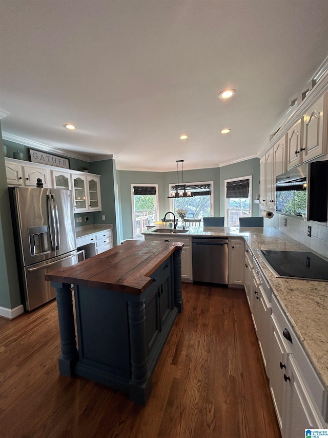 kitchen featuring dark wood-style flooring, white cabinetry, wooden counters, appliances with stainless steel finishes, and crown molding